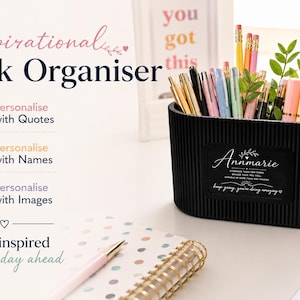 May include: A black desk organizer filled with pens, pencils, and highlighters. The organizer has a label that says "Annmarie" and "Keep going, you're doing amazing." The image also includes a notebook, pen, and the text "Inspirational Desk Organiser."