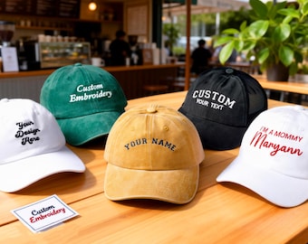 May include: A collection of baseball caps in various colors, including white, green, black, and yellow. Each cap features custom embroidery with phrases like "Your Design Here" and "Your Name". The caps are displayed on a wooden table.
