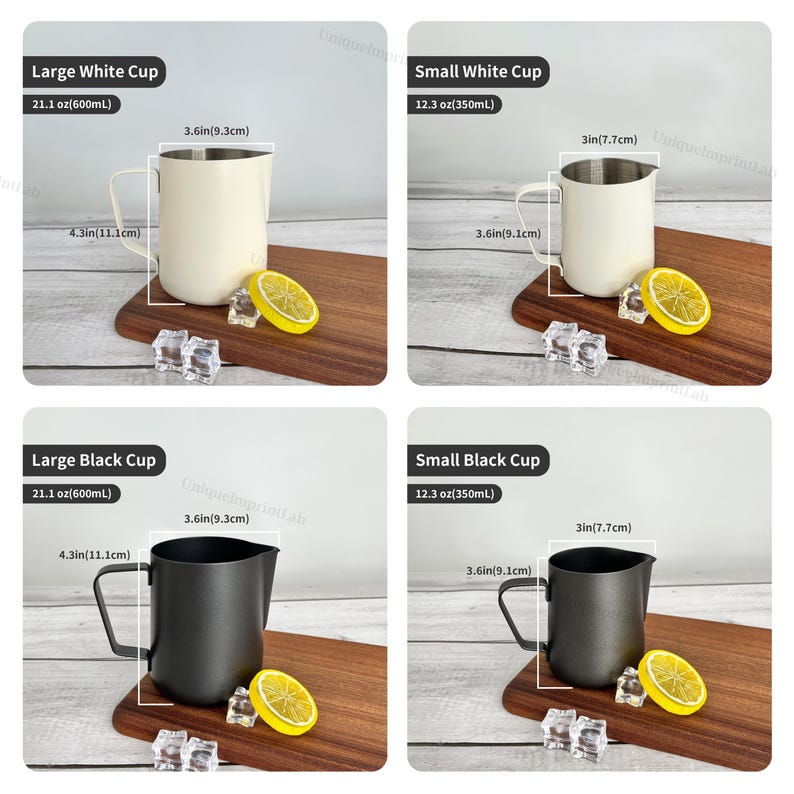 May include: Four stainless steel milk frothing pitchers, two white and two black, with measurements in inches and ounces. Each pitcher is on a wooden board with a lemon slice and ice cubes.