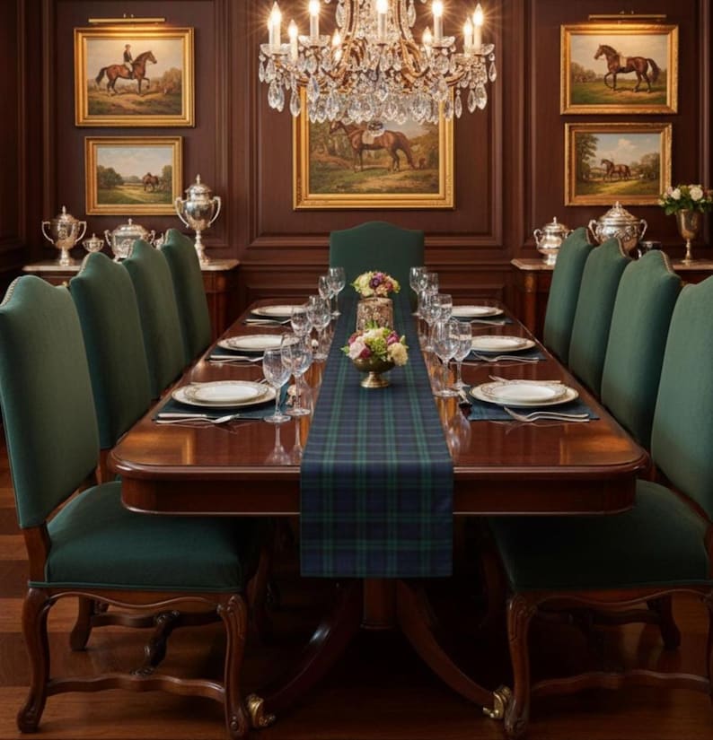 Op de afbeelding: Een formele eetkamer met een grote houten tafel gedekt voor een maaltijd. Groene gestoffeerde stoelen omringen de tafel, die is versierd met een geruite loper, couverts en bloemstukken. Kunstwerken van paarden hangen aan de met hout beklede muren.