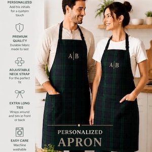 Puede incluir: Dos delantales a juego con un patrón de cuadros en verde oscuro y azul marino. Cada delantal incluye tiras negras para el cuello, dos bolsillos delanteros y las iniciales A|B bordadas en el centro. El texto PERSONALIZED APRON aparece abajo.