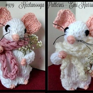 May include: Two knitted white mice with pink ears, one wearing a pink scarf and the other a white scarf, each holding a bouquet of white flowers.