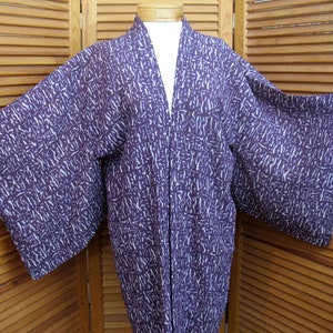 Puede incluir: Un kimono japon&eacute;s de manga larga con estampado morado y blanco. El kimono est&aacute; hecho de una tela suave y ligera y tiene un corte holgado.