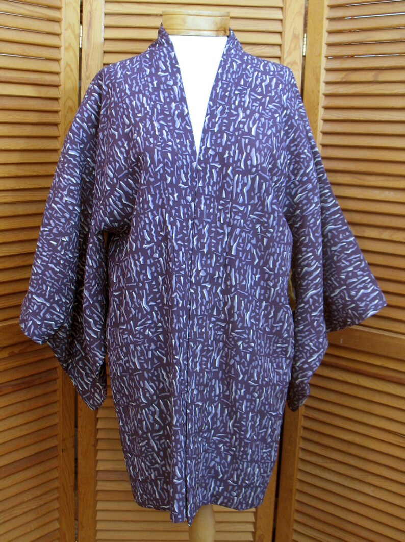 Puede incluir: Un kimono de manga larga con un estampado morado y blanco. El kimono est&aacute; hecho de una tela suave y ligera y tiene un corte holgado.