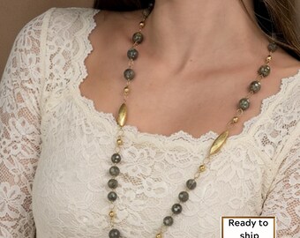 May include: A long necklace with grey gemstone beads and gold-coloured accents. The necklace has a delicate chain and includes two elongated gold-coloured pendants. The image also includes the text "Ready to ship".