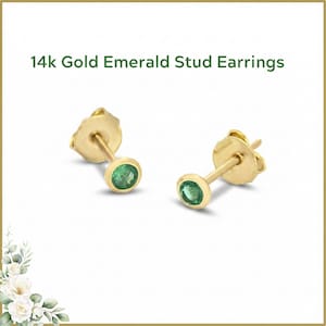 May include: A pair of 14k gold stud earrings with emerald gemstones. The earrings have a post and backing design. The text "14k Gold Emerald Stud Earrings" is displayed at the top of the image.