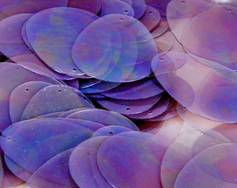 May include: A pile of iridescent purple oval sequins with two holes in each sequin.