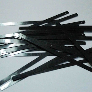 Puede incluir: Un montón de tiras de metal negro con pequeños agujeros.
