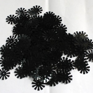 Puede incluir: Un montón grande de lentejuelas negras en forma de estrella. Las lentejuelas son brillantes y tienen un acabado metálico.