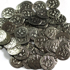 Op de afbeelding: Een stapel zilverkleurige metalen tokens met Hebreeuwse letters. De tokens zijn rond en hebben een verhoogde rand.
