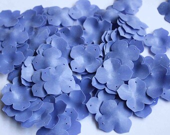 May include: A large pile of light blue fabric flower petals. The petals are made of a soft, velvety material and have a slightly textured surface.