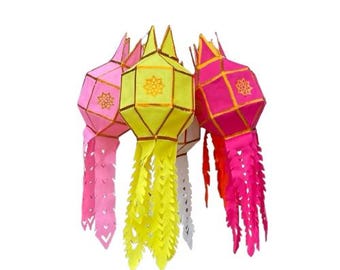 May include: A cluster of colorful paper lanterns in shades of pink, yellow, and white. Each lantern has a geometric design with decorative cutouts and a tassel-like fringe. The lanterns are suspended against a white background.