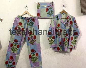 May include: A pajama set with a floral pattern. The set includes pants, a button-down shirt, and a matching pouch. The fabric features a checkered background with red floral designs and green leaves. The text "textilehandicrafts" is visible.