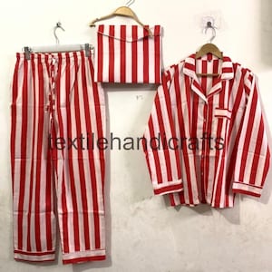 May include: A red and white striped pajama set, including pants, a button-down shirt, and a matching pouch. The set is displayed on hangers against a plain background. The text "textilehandicrafts" is visible.