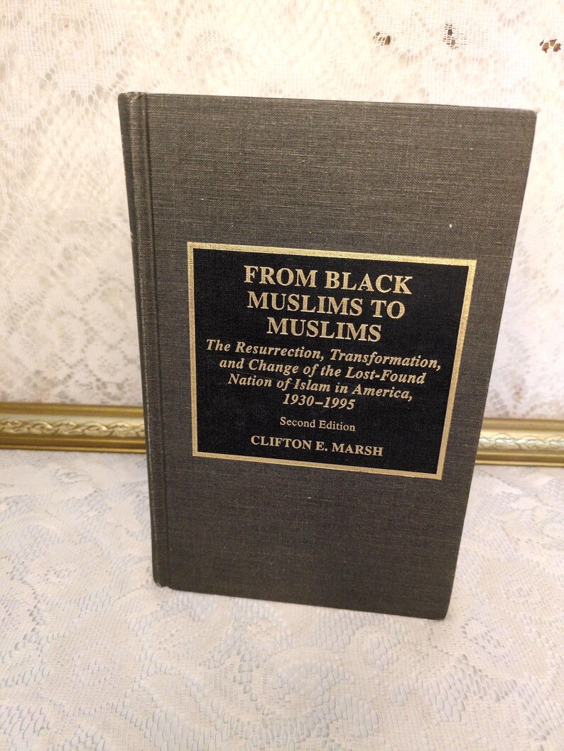 May include: A hardcover book titled "FROM BLACK MUSLIMS TO MUSLIMS" with gold lettering on a black rectangular label. The book's cover is a dark gray color. The text below the title reads "The Resurrection, Transformation, and Change of the Lost-Found Nation of Islam in America, 1930-1995".
