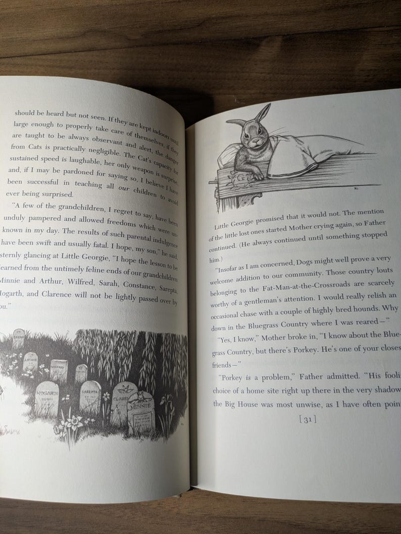 May include: An open book with black text on white pages. The left page features a black and white illustration of several gravestones in a grassy area. The right page shows a black and white drawing of a rabbit resting its paws on a wooden ledge.