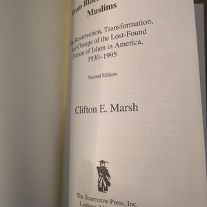 May include: Open book with the title "From Black Muslims to Muslims" and the subtitle "The Resurrection, Transformation, and Change of the Lost-Found Nation of Islam in America, 1930-1995." The author is Clifton E. Marsh. Published by The Scarecrow Press.