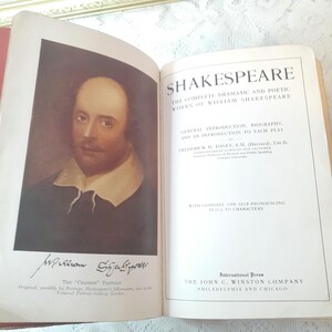 May include: Open book with a portrait of William Shakespeare on the left page and the title "SHAKESPEARE" on the right. The book is a collection of Shakespeare's dramatic and poetic works, published by The John C. Winston Company.