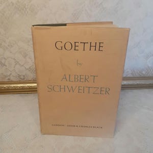 May include: A tan-colored book with the title "GOETHE" by "ALBERT SCHWEITZER" printed on the front cover. The book is published by "LONDON: ADAM & CHARLES BLACK".