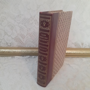 May include: A hardcover book titled "Tales From The Decameron" by Boccaccio. The spine is burgundy with gold lettering and decorative elements. The book's cover has a tan, patterned design. The book is standing upright.