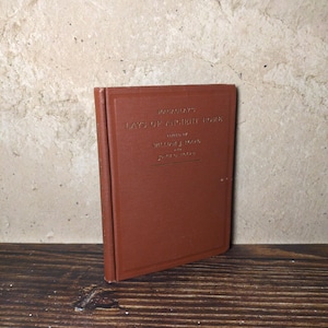 May include: A brown hardcover book titled Macaulay's Lays of Ancient Rome, edited by William J. Rolfe with John C. Rolfe. The front cover features embossed gold lettering and a simple rectangular border design on the textured material.