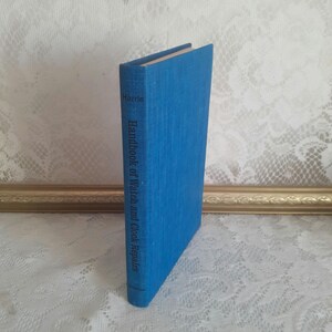 May include: A blue hardcover book titled "Handbook of Watch and Clock Repairs" by Harris.