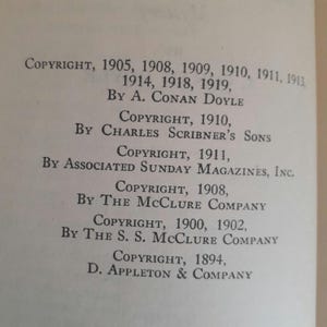 K&ouml;nnte beinhalten: Nahaufnahme einer Buchseite mit Copyright-Informationen. Der Text enth&auml;lt Copyright-Daten von 1894 bis 1919, mit Namen wie A. Conan Doyle und Charles Scribner's Sons. Die Seite ist cremefarben.