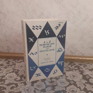 May include: A vintage book titled "A to Z Horoscope Maker and Delineator" by Llewellyn George. The cover features a blue and white design with astrological symbols.