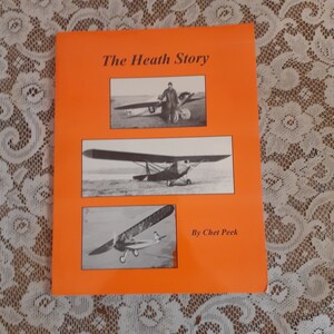 May include: An orange book cover with the title "The Heath Story" and the author "By Chet Peek". The cover features three black and white photos of vintage airplanes.