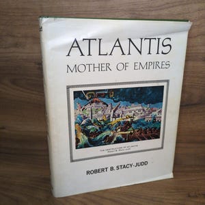 May include: A hardcover book titled "ATLANTIS MOTHER OF EMPIRES" by Robert B. Stacy-Judd. The cover features an illustration of a city with a volcano erupting and the sea. The book has a white cover with black text.