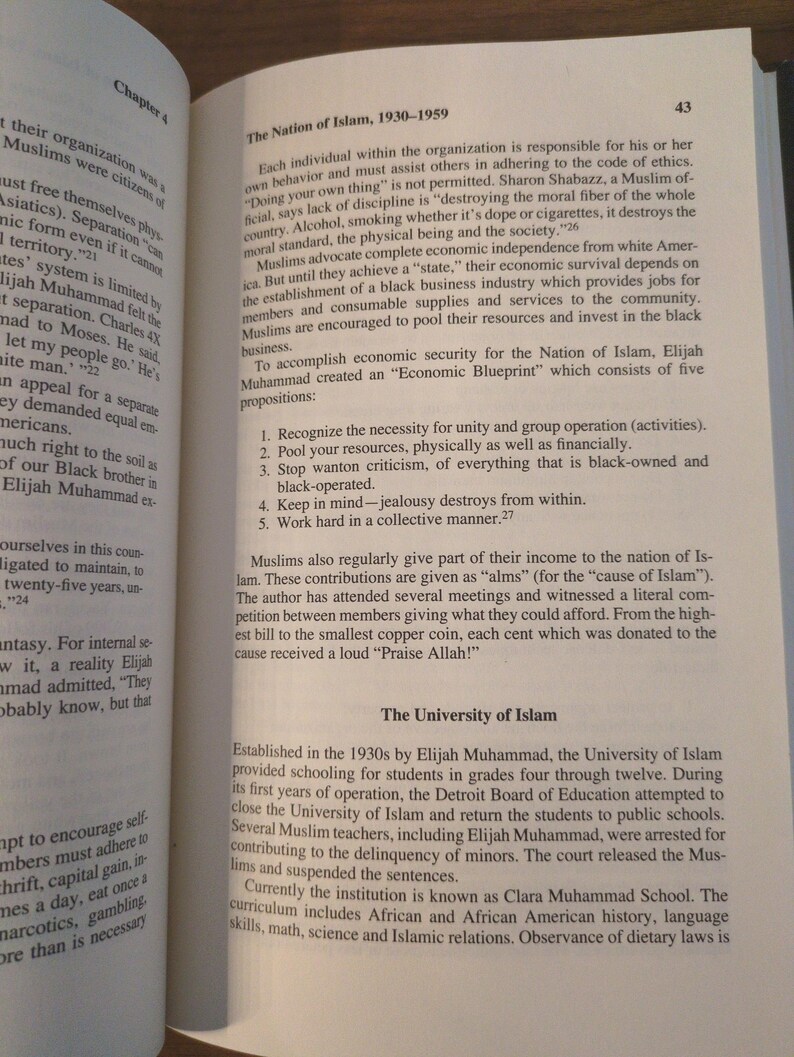 May include: Open book with text about The Nation of Islam, 1930-1959, and The University of Islam. The text discusses economic independence, community, and the educational institution's history. The page numbers are visible.