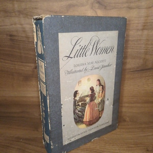 May include: A vintage copy of "Little Women" by Louisa May Alcott, illustrated by Louis Jambor. The book has a blue cover with the title in elegant script and a color illustration of women. The book is part of the Illustrated Junior Library.
