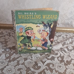 May include: A vintage Little Golden Book titled "Bil Baird's Whistling Wizard" with a green cover featuring an illustration of a leprechaun, a boy, and a horse.