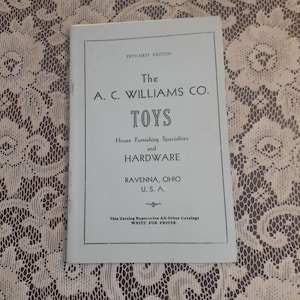 May include: A vintage catalog titled "The A.C. Williams Co. Toys" with the text "FIFTY-FIRST EDITION" at the top. The catalog also lists "House Furnishing Specialties and HARDWARE" and the location "RAVENNA, OHIO U.S.A."