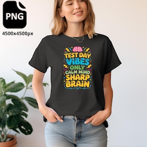 Peut inclure: T-shirt noir avec l'inscription "TEST DAY VIBES ONLY CALM MIND SHARP BRAIN" en lettres colorées. Le motif comprend un cerveau et des éclairs. Le t-shirt est à col rond.