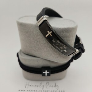 Könnte beinhalten: Schwarzes Silikonarmband mit einem silbernen Kreuz und der Inschrift "Fürchte dich nicht, denn ich bin mit dir. Jesaja 41:10".