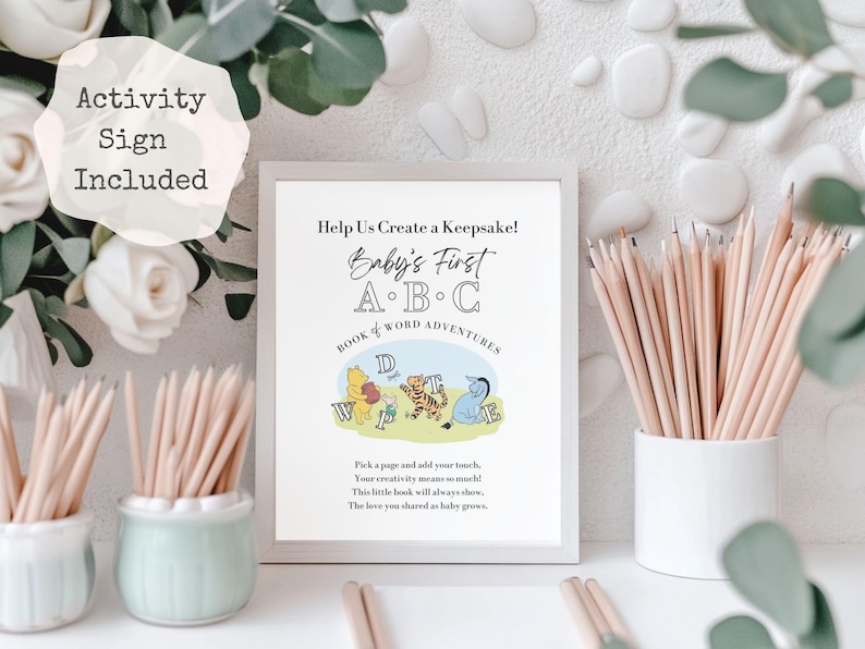 May include: A framed print with the text "Help Us Create a Keepsake! Baby's First A.B.C Book & Word Adventures" featuring Winnie the Pooh characters. Pencils are in small white and light green ceramic pots. The words "Activity Sign Included" are in a white circle.