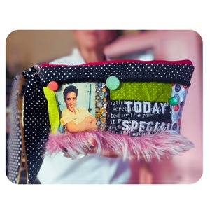 Peut inclure: Une pochette zippée avec une bordure supérieure à pois noirs et blancs, une impression photographique centrale d'Elvis Presley, un panneau noir avec le texte blanc TODAY SPECIAL et une bordure inférieure en fausse fourrure rose avec des accents circulaires.