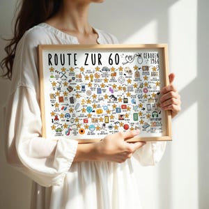 May include: A framed print with the text "ROUTE ZUR 60" and "GEBOREN 1966". The print is filled with various hand-drawn icons and stars, with the words "HAPPY BIRTHDAY! 2026" at the bottom. The frame is made of light-colored wood.