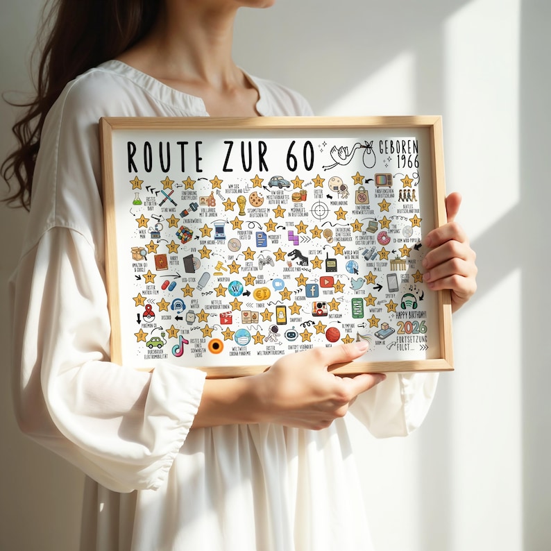 May include: A framed print with the text "ROUTE ZUR 60" and "GEBOREN 1966". The print is filled with various hand-drawn icons and stars, with the words "HAPPY BIRTHDAY! 2026" at the bottom. The frame is made of light-colored wood.