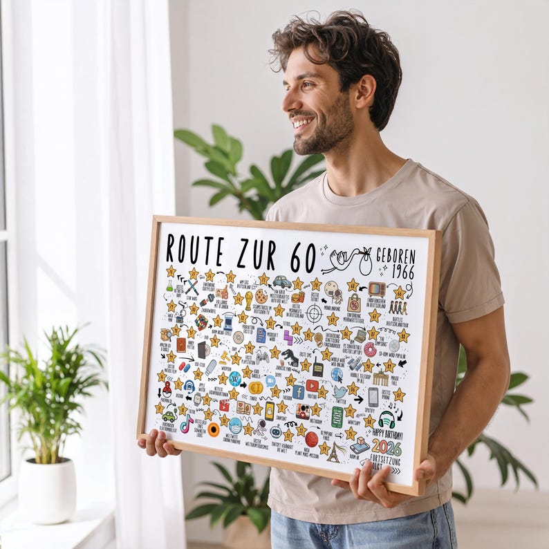 May include: A framed print with the text "ROUTE ZUR 60" and "GEBOREN 1966" in black. The print is filled with small illustrations and star accents. The frame is a light brown color.