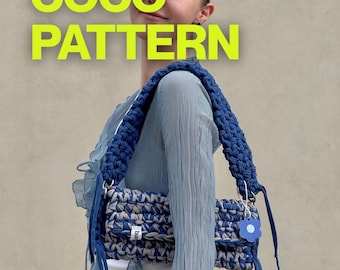 May include: A rectangular crochet shoulder bag featuring a blue and grey marled yarn pattern with a thick, braided blue strap. The bag includes a small blue flower-shaped charm and a white tag with text. The text COCO PATTERN appears in bright yellow.