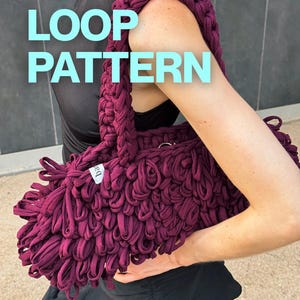 May include: A deep burgundy handbag crafted with a textured loop pattern made from fabric strips. The bag features a thick, braided shoulder strap and a small white label on the side. The text LOOP PATTERN is overlaid in light blue on the image.