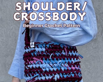 Könnte beinhalten: Eine handgefertigte Schulter-/Umhängetasche in einem Häkelmuster für Anfänger. Die Tasche ist eine Mischung aus bordeauxfarbenem, hellblauem und rosa Garn. Der Riemen ist ein geflochtenes Design in Blau. Der Text auf dem Bild lautet "SHOULDER/CROSSBODY Beginner Crochet Pattern."