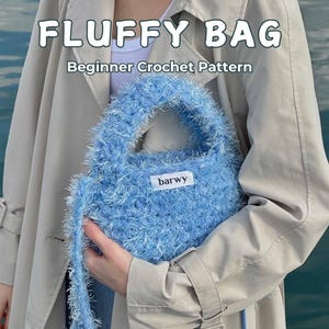 Può includere: Una borsa all'uncinetto blu chiaro e soffice con un manico corto. La borsa ha un'etichetta con la scritta "barwy". Il testo "FLUFFY BAG" e "Beginner Crochet Pattern" sono visualizzati in lettere bianche.