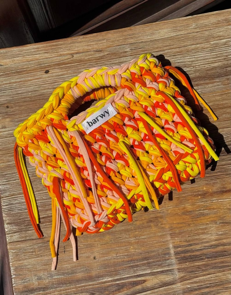 K&ouml;nnte beinhalten: Handgewebte Handtasche in Gelb-, Orange- und Rosat&ouml;nen. Die Tasche hat einen Griff und Fransen. Auf dem Etikett der Tasche steht "barwy".