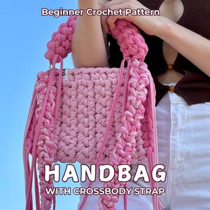 Peut inclure: Sac à main rose en crochet avec une bandoulière. Le sac présente un motif tissé et de longues franges pendantes. Le texte sur le sac indique "HANDBAG WITH CROSSBODY STRAP" et "Beginner Crochet Pattern".