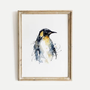 Puede incluir: Pintura a la acuarela de un pingüino en un marco dorado. El pingüino está representado con tonos negros, amarillos y azules, con pinceladas sueltas y salpicaduras. La obra de arte está enmarcada y lista para colgar.