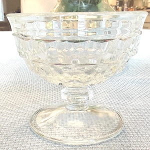 May include: Clear glass dessert dish with a wide, textured bowl and a stemmed base. The bowl features a geometric pattern, and the base is round. The dish is designed for serving desserts.