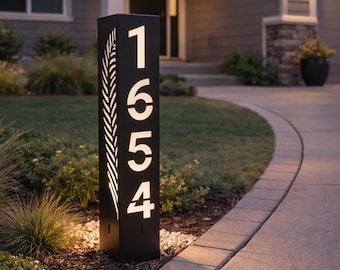 Letrero metálico con número de casa: Columna metálica alta para jardín con números de casa iluminados.